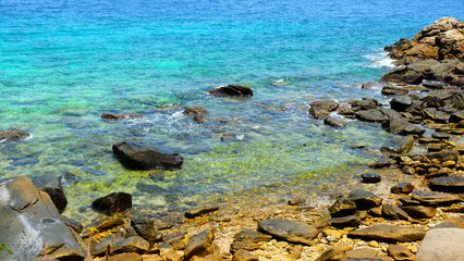 Stone reef beach with colorful sea water background for decoration on natural theme concept.