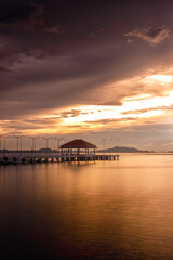 Fototapeta na wymiar Sunset seascape with bridge and dramatic sky.