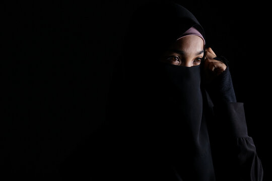 Portrait of Beautiful Muslim Woman in niqab on black background