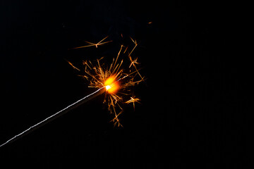 A lit sparkler showing bright sparks