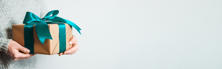 Female hands hold gift box on white background, copy space right. Unrecognizable caucasian girl in...