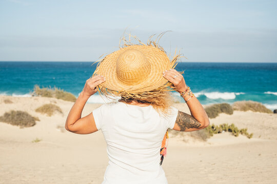 Outdoor Beach Summer Holiday Travel Vacation Concept With Unrecognizable Woman With Tourist Hat Enjoying The Beach With No People And Looking At The Ocean With Blue Sky And Horizon