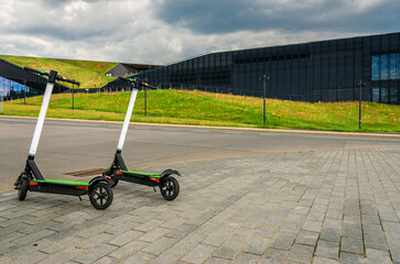 Electric transport: kick electric scooter in urban city lifestyle background. Electric urban transportation concept.