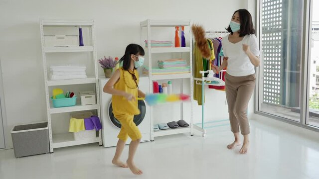 Asian mom and kid happy funny doing chore housework at home, Family chore homecleaning concept