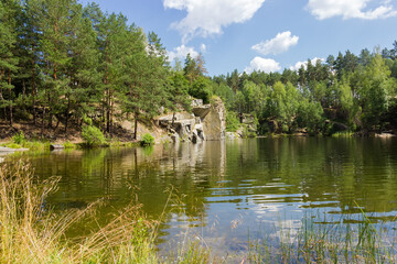 Fototapeta na wymiar Scenic forest lake with rocky shore in summer