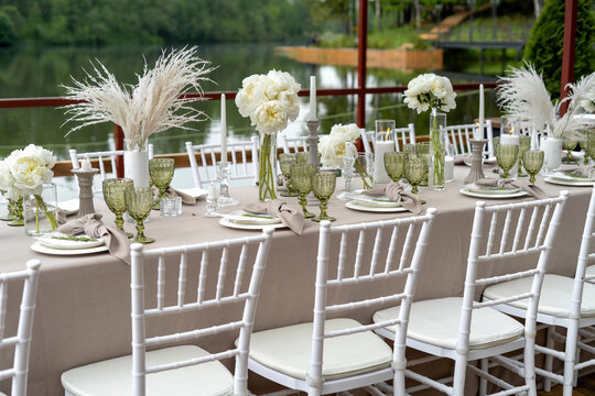 Decorated wedding table, white peonies and feathers. Chiavari chairs are at the table-2.