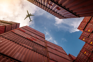 Airplane flying above container logistic. Cargo and shipping business. Container ship for import and export logistic. Logistic industry from port to port. Container at harbor for truck transport. - obrazy, fototapety, plakaty