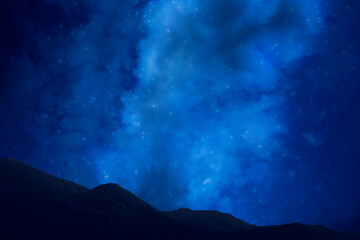 Photo of the night sky with the milky way and stars. The dark silhouette of the mountains. Tourism.