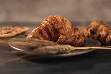 bakery scene, lunch. a croissant, other pasta and wheat spikes, front shot