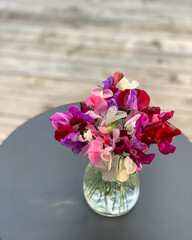 Bouquet sweet peas, vertical minimalist design, table, wooden grungy background. Photography from above. Backdrop, banner, for social media, greeting or invitation cards, copy space, place for text