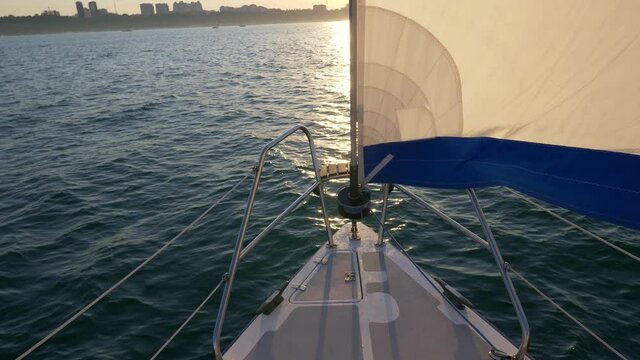 yacht at sea at sunset, bow with white sail, summer leisure, sailing tourism, yachting sport