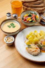 Egg and meat roulade with mashed potato as a part of a whole meal in a cafe, high angle photo, fully set table