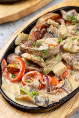 Close up of vegetable portobello in white sauce in cast-iron skillet