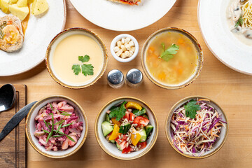 Fototapeta na wymiar Menu photo of different kinds of salads and soups, directly above studio shot, full table