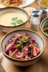 Russian beetroot salad with pickles and boiled potato, served in a small bowl, as a part of business lunch
