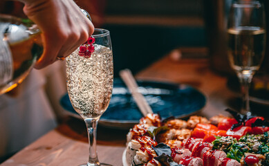 hand with bottle wine or champagne pouring in wine glass. © pavel siamionov