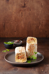A cut Chicken doner kebab in roll of pita bread lavash. Shawarma Sandwich on a wooden background