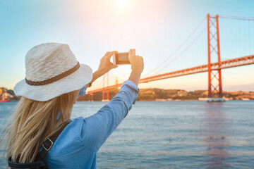 Young traveler woman with smartphone takes pictures in Lisbon