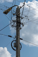 power pole with a lantern and lots of cables