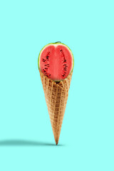 Half a sweet red watermelon in wafer cone over turquoise background. Healthy nutrition, seasonal harvest of berries and fruits. Close up, copy space