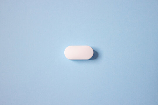White tablet on a blue background, top view.