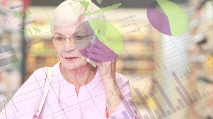 Financial data processing against senior woman talking on smartphone while grocery shopping - Powered by Adobe
