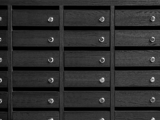 Rows of wooden unnumbered mailboxes and lockers.