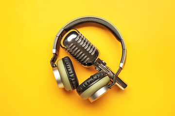 Headphones with microphone on color background