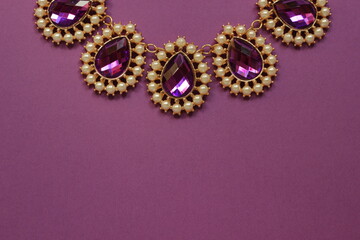 luxury purple jewelry in the Baroque style on a purple background. Vintage, retro style.
copy space
