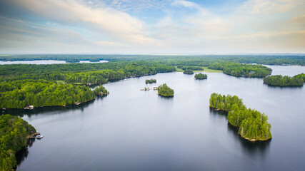 Aerial view of a lake in Canada. Multiple islands and a cloudy sky are visible in the image. The picture was captured with a drone.