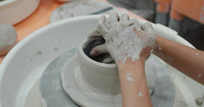 Making ceramic pot on turning pottery wheel