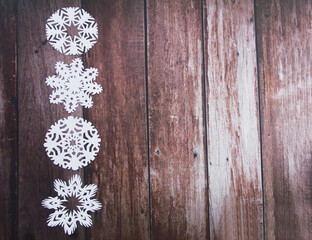 white Christmas snowflakes on a wooden background