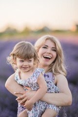 Fototapeta na wymiar women on lavander field with baby in dress, blond long hair feel happy