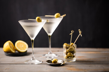 2 glasses of martini with olives. On a wooden background. Landscape