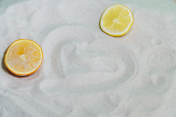 slices of citrus fruit on white sand