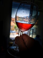 a glass of red wine held in his hand by twirling it