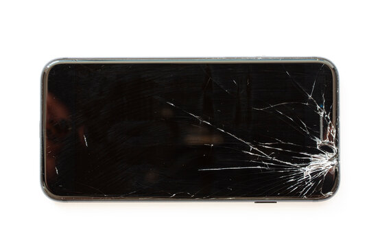 Mobile Cell Phone With Broken Display Screen After Drop. Crashed Black Smartphone On White Background. Flat Lay Image Seen From Above.