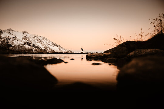 Silhouette of man standing on rock during sunset