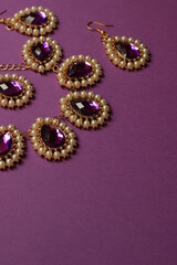 luxury purple  jewelry in the Baroque style on a purple background. Vintage, retro style.
copy space
