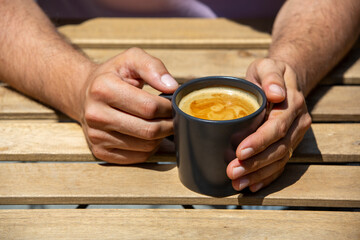 Fototapeta na wymiar Man hand holding coffee cup on wooden table