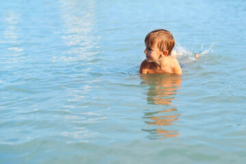 Cute boy swimming in water. Happy kid on summer vacations.