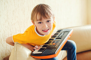 Boy learning to play the synthesizer. Music education and extra-curricular lessons.