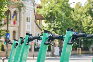 Row of green-blue electric scooters, a cleaner, modern alternative transportation option in cities. Close up.