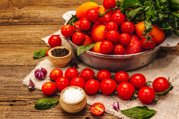 Assorted ripe multicolored tomatoes. Young garlic, fresh basil leaves, salt, spices