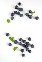Blueberry fruit top view isolated on a white background, flat lay overhead layout with mint leaf, healthy design concept.