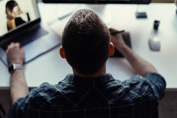 Handsome freelancer man working remotely from home. Young male working on his computer