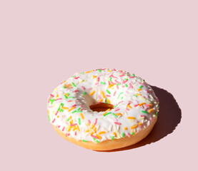  Donut with white frosting and colorful sweet sugar sticks. on a pink background. View from above.pattern. High quality photo