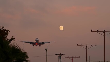Airplane landing in LAX airport at sunset, Los Angeles, California USA. Passenger flight or cargo...