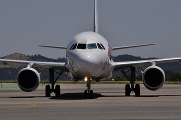 Fototapeta na wymiar Vista frontal de avión de línea en aeropuerto