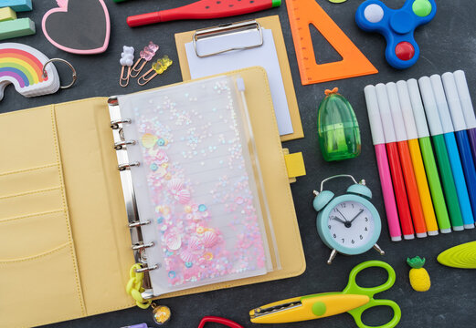 Stationery chalk board. Back to school. Open notepad on top of office supplies.